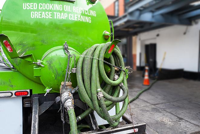 a grease trap pumping truck at a restaurant in Coconut Creek FL